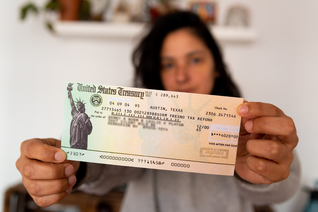 woman holding check from U.S. Treasury