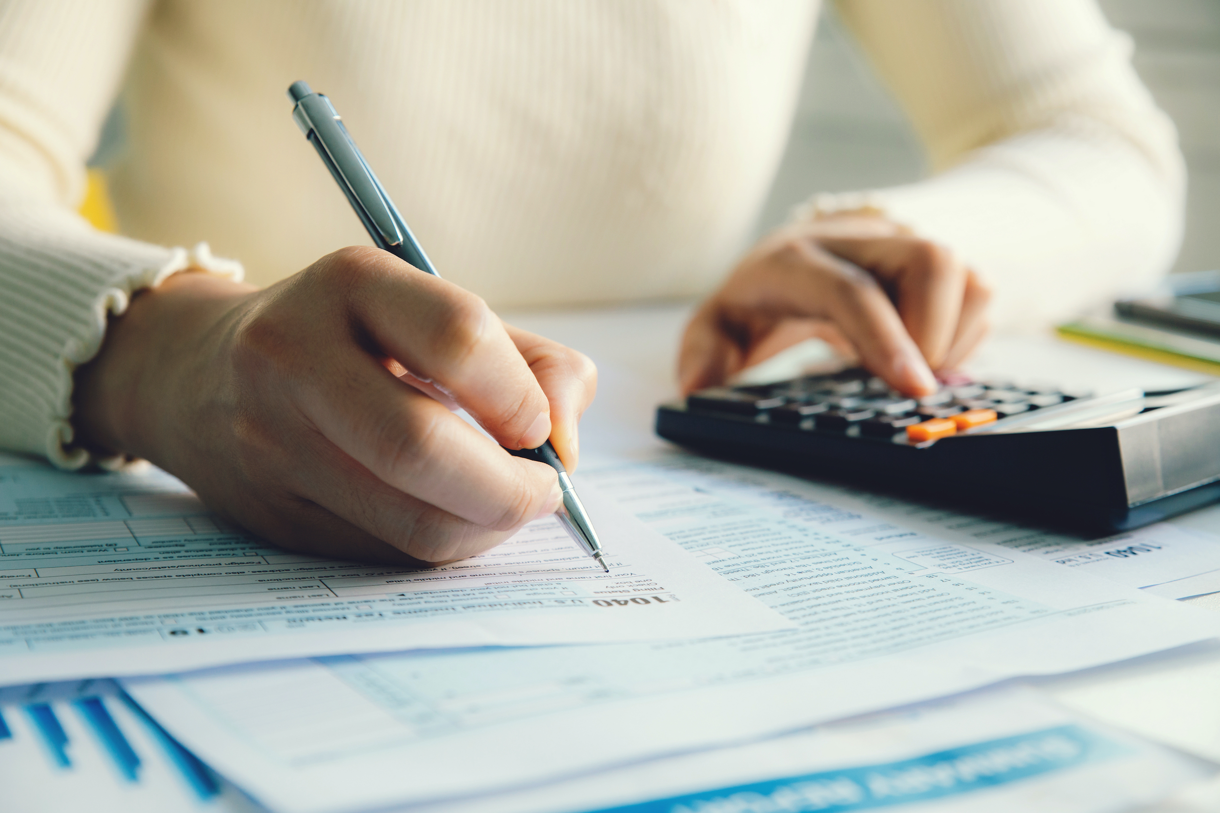 Closeup woman filling form of Individual Income Tax Return