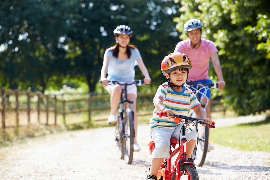 Family of three riding bicycles outside